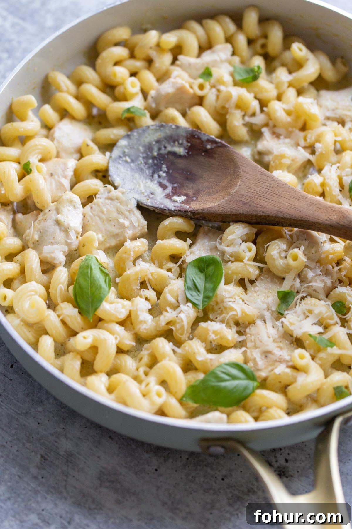 Creamy Harissa Pasta Recipe 4 Creamy pesto cavatappi in a skillet with a wooden spoon.