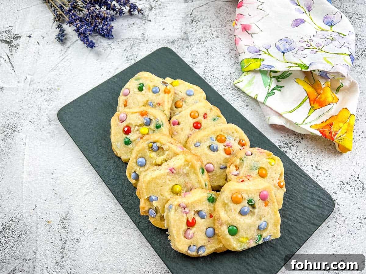 19 Cookie Recipes Even Dessert Skeptics Can't Resist 6 Shortbread M&M cookies on a black plate with flowers.