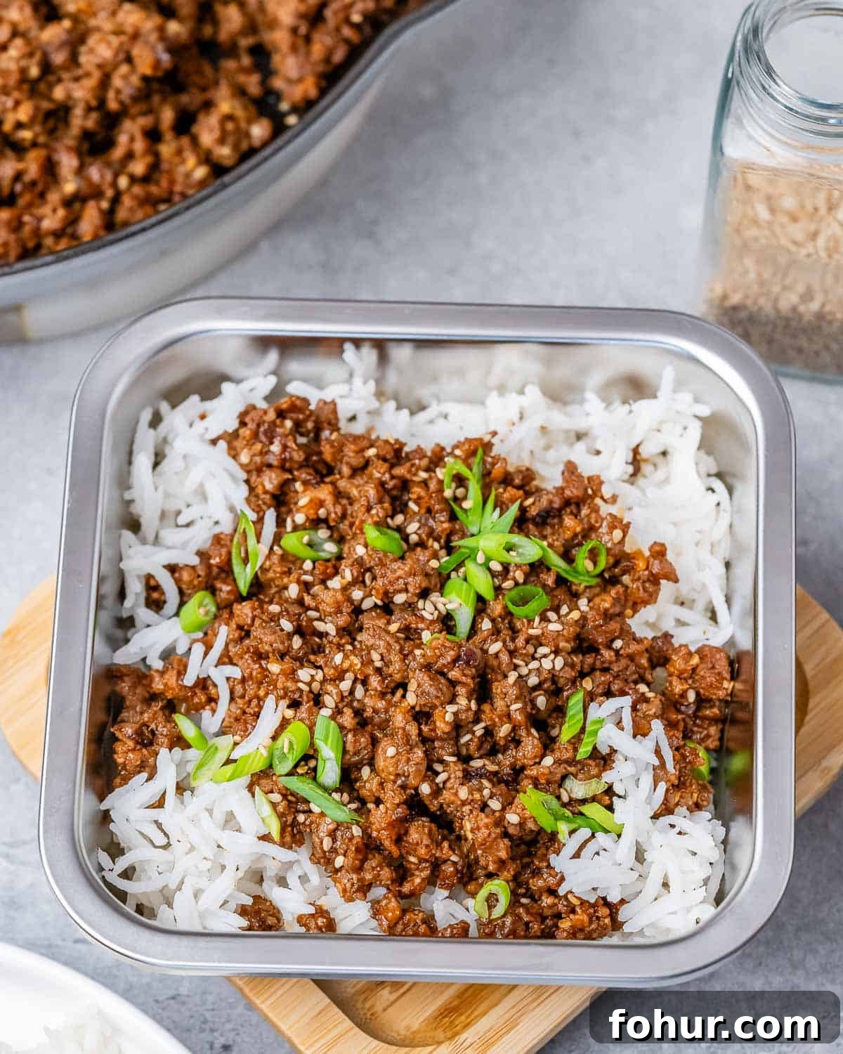 A square container filled with rice and ground beef on top.