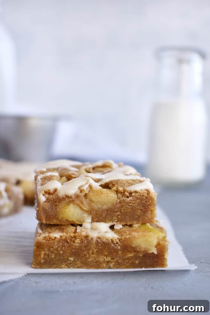 stack of two blondies with milk in background.