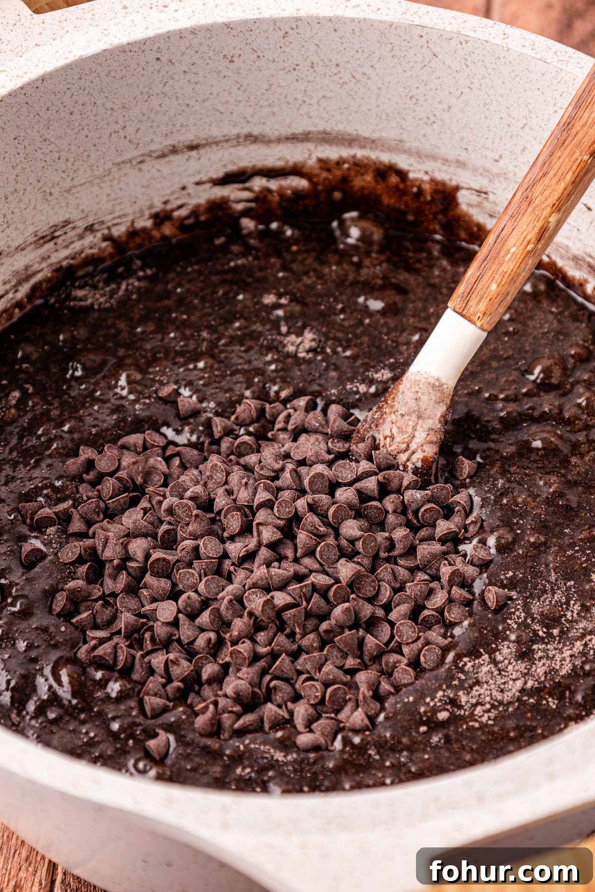 Decadent Baileys Irish Cream Brownies Recipe 5 A pot of brownie batter with chocolate chips being folded in.